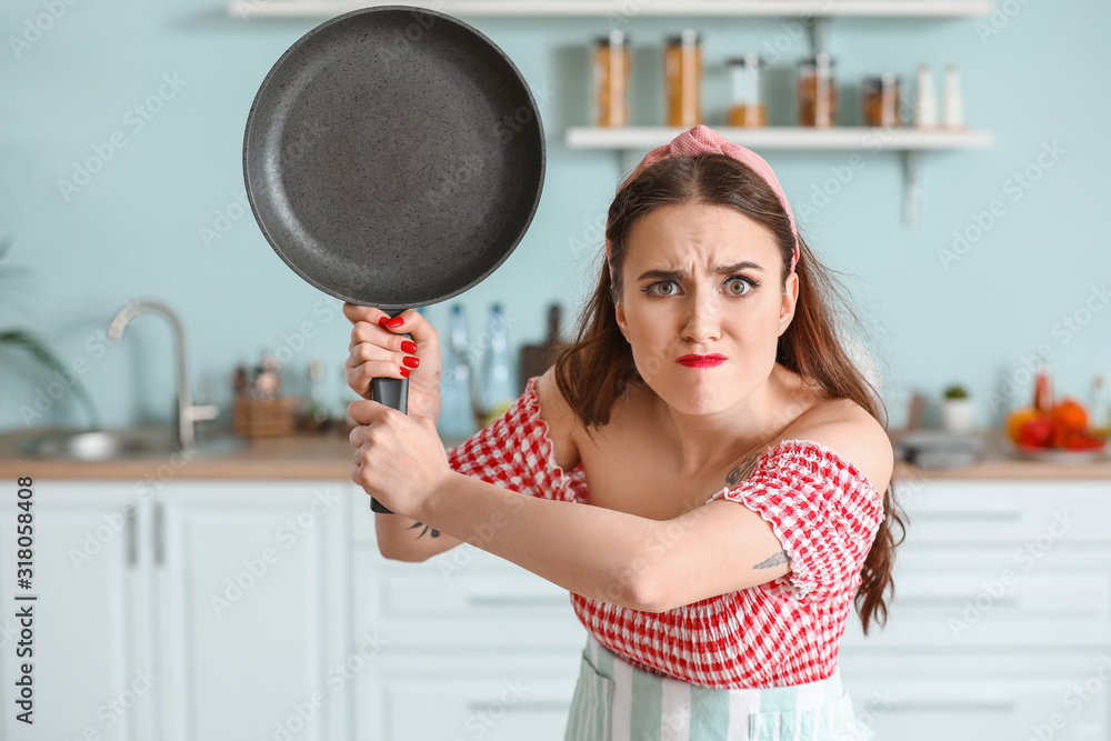 Funny angry housewife in kitchen