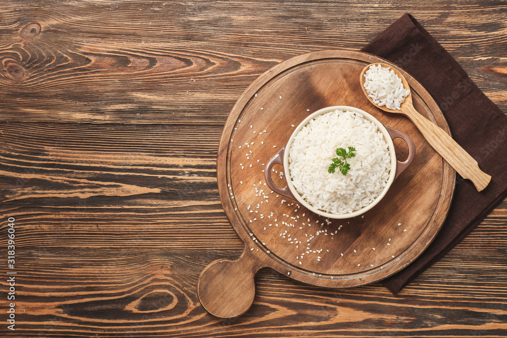 Pot with boiled rice on wooden table