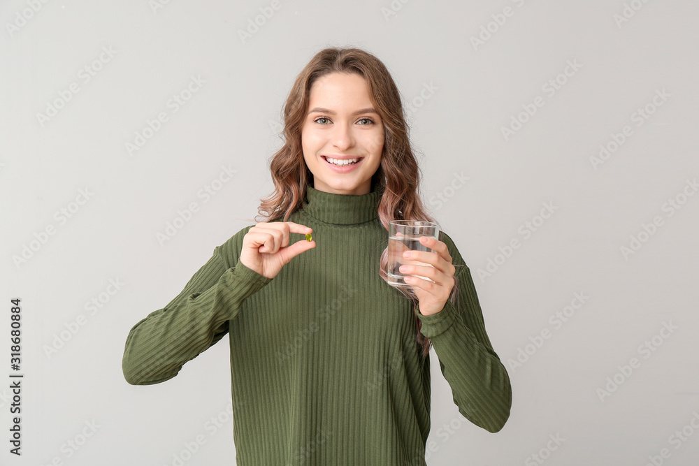 浅背景鱼油的年轻女人