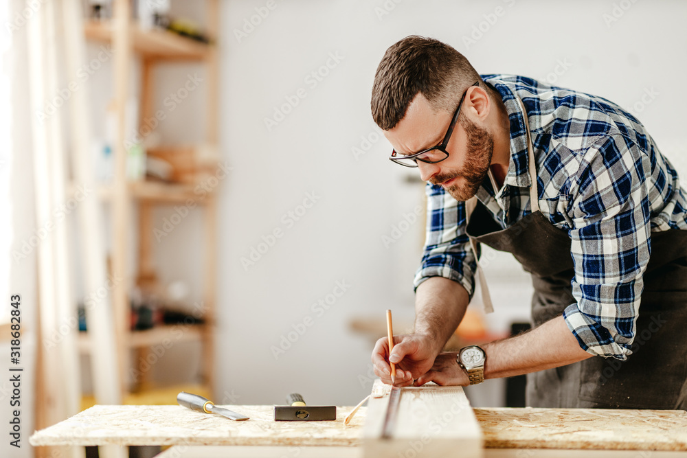 在车间工作的年轻男性木匠。