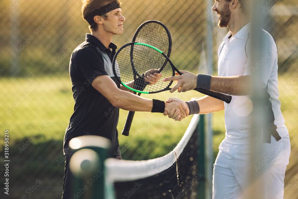 Tennis players shaking hands at net