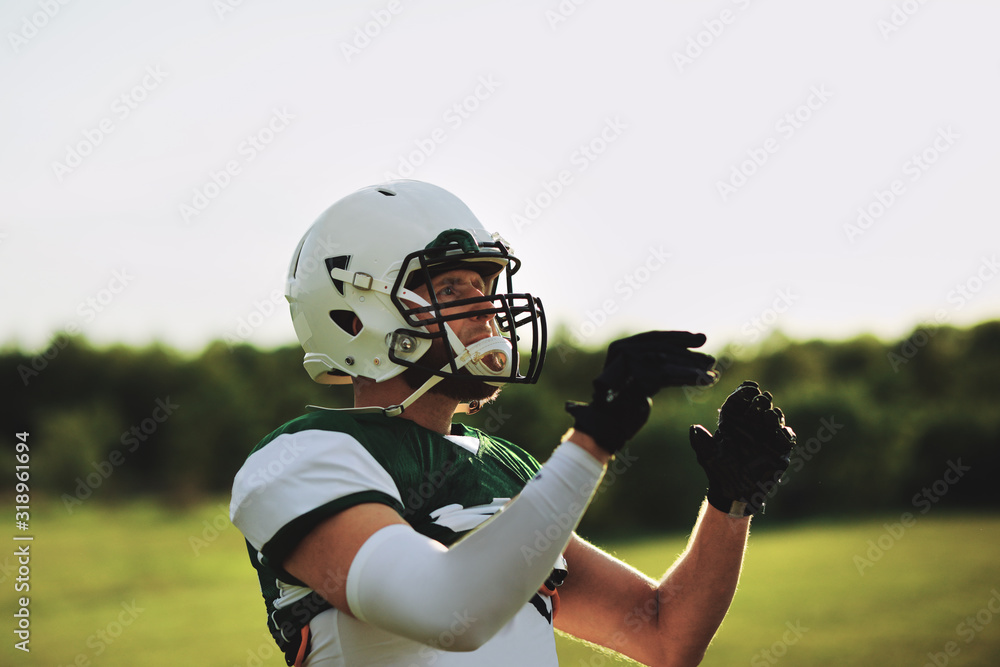 American football receiver about to catch a ball during practice