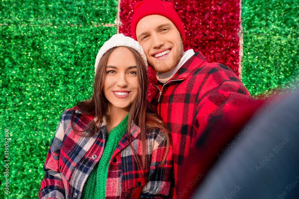 Happy young couple taking selfie on color background