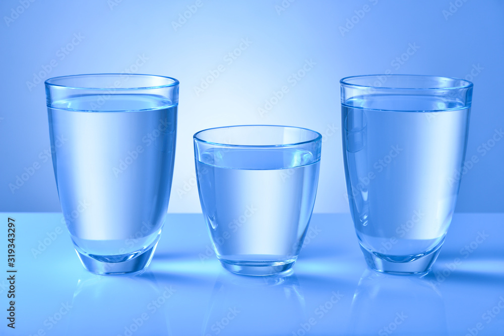 Glasses of fresh water on color background