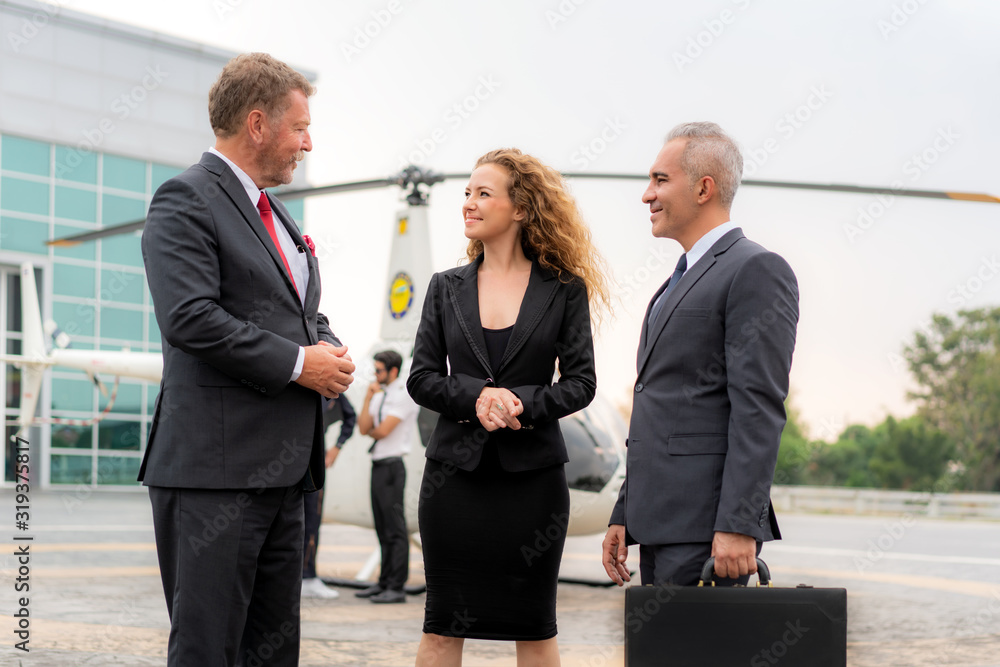 Three Businesswoman And Businessman In Discussion with Briefcase standing near helicopter when he ar