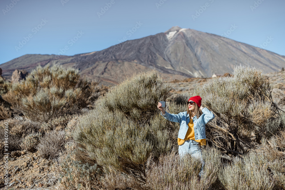 年轻女子在火山谷旅行时通过电话拍照或视频记录。生活方式tr