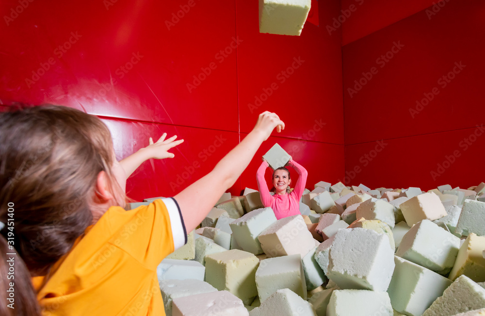 Family having fun in soft box pool in trampoline center