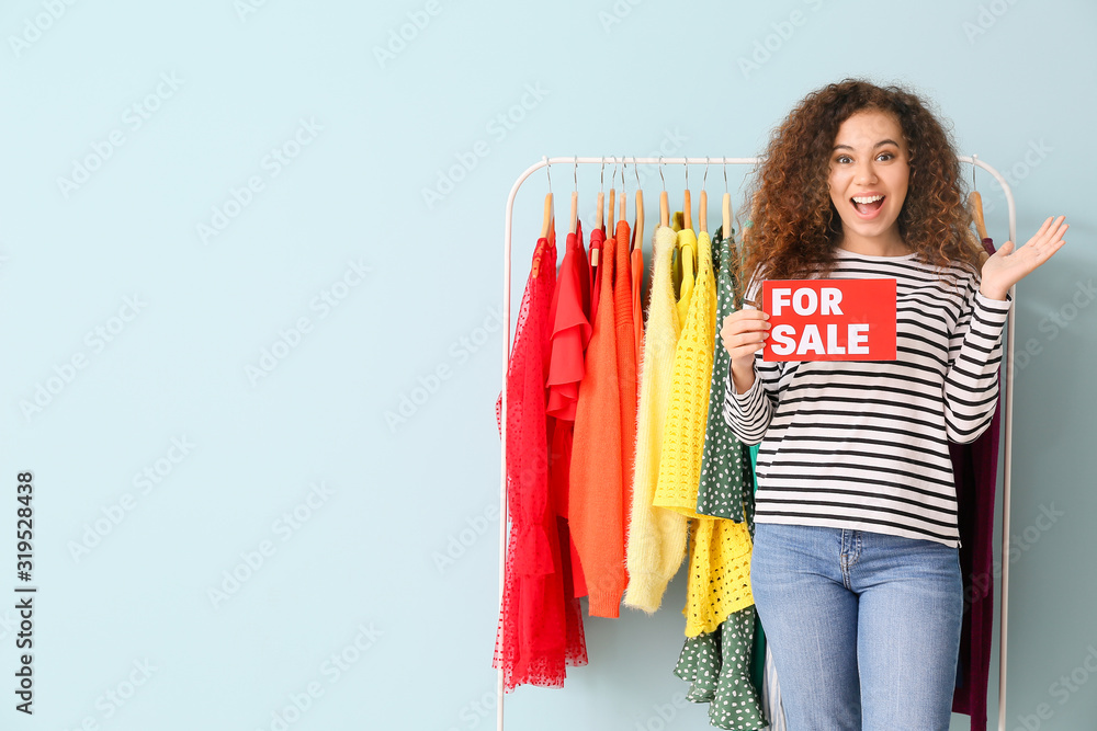 African-American stylist near rack with modern clothes