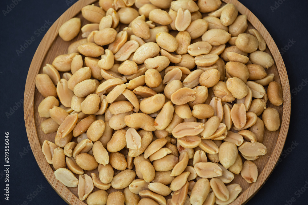 Peanuts Nut mixed salt in a wooden plate is Protein food and healthy food for diet food on a black b