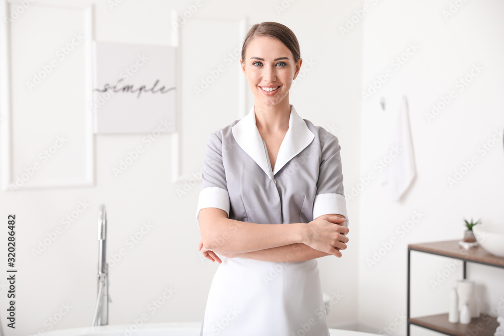 Beautiful chambermaid in hotel bathroom