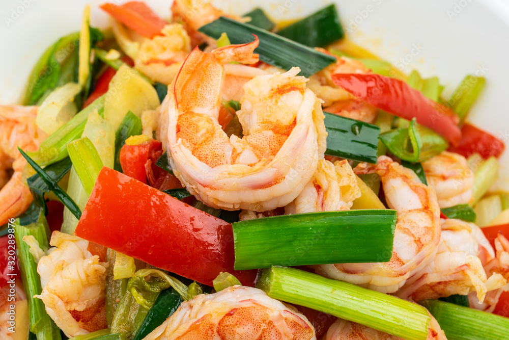 Stir-fried shrimp with celery in a dish on white background