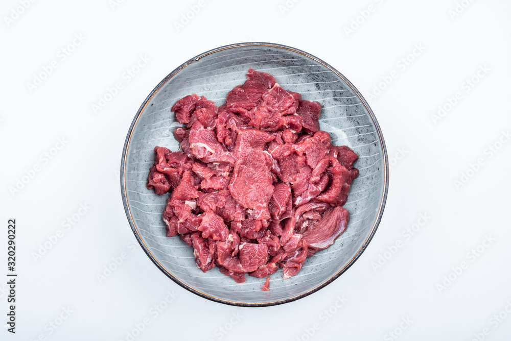 Fresh beef slices on a plate on white background