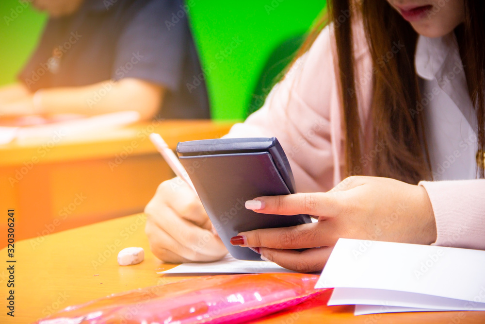 Hands university student holding pen writing /calculator doing examination / study or quiz, test fro