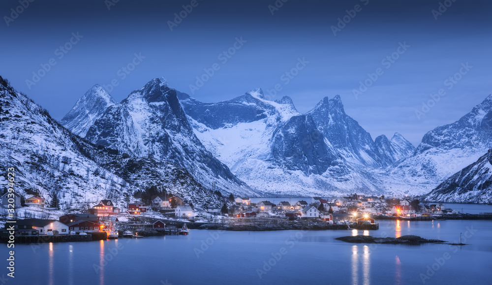 村庄里的房子，城市的灯光，雪山，大海，蓝色多云的天空在夜晚反射在水中