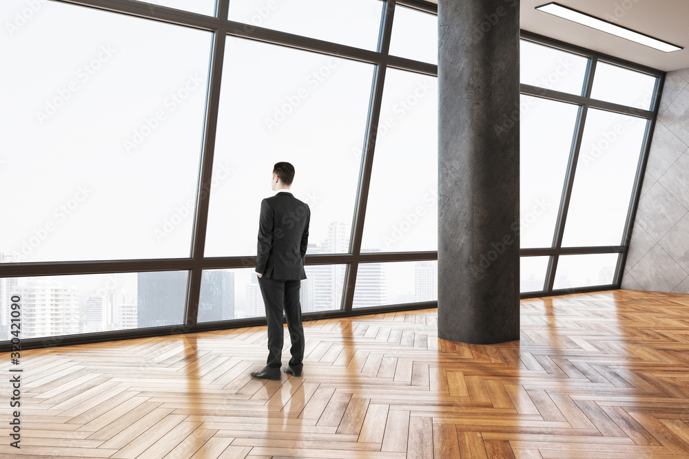 Businessman standing in minimalistic gallery interior