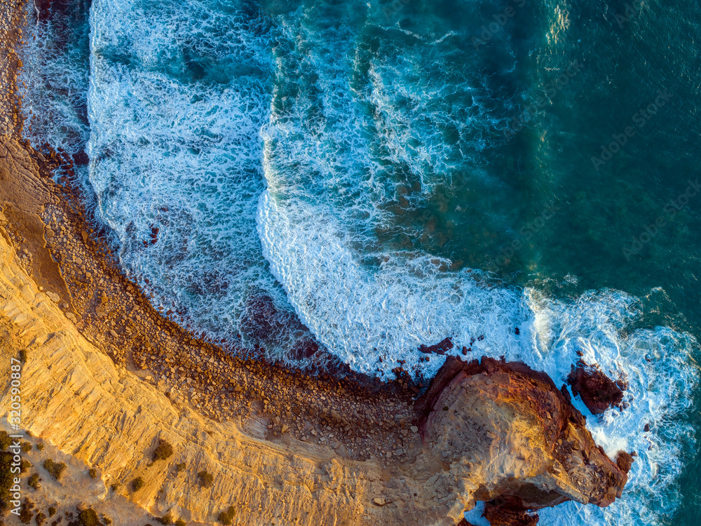 Aerial top view on rock cliffs and waves