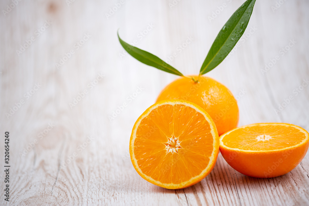 Natural fresh fruit oranges in a wooden background backdrop, half cut oranges, orange juice, vitamin