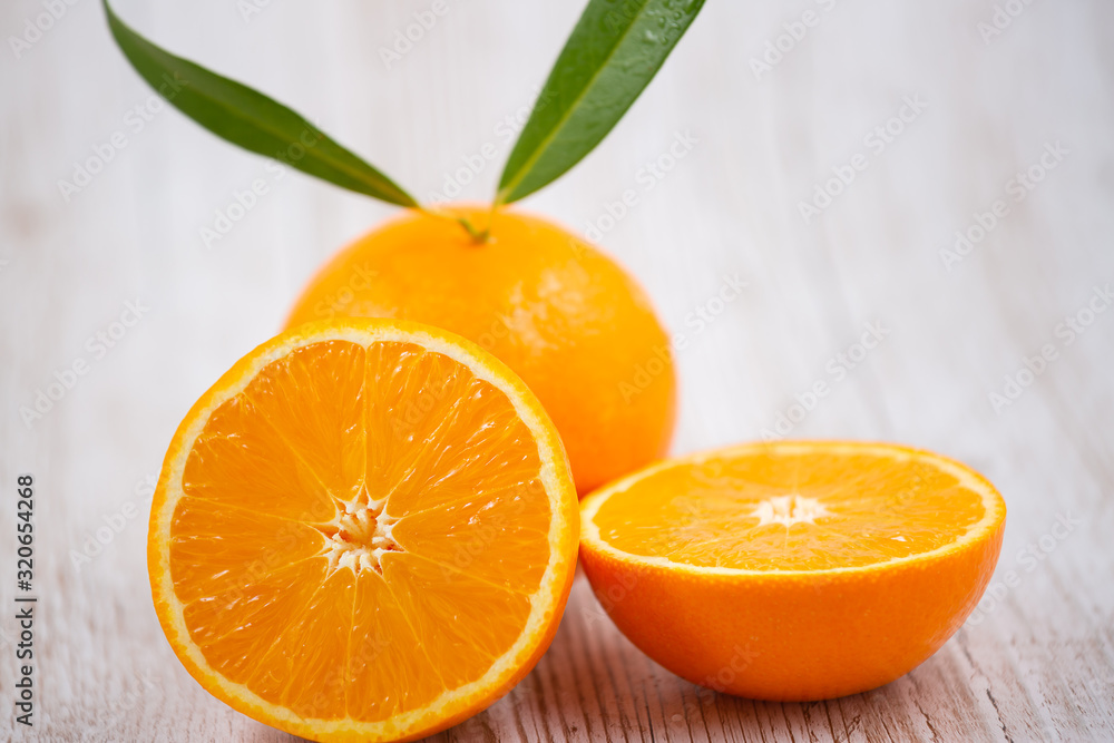 Natural fresh fruit oranges in a wooden background backdrop, half cut oranges, orange juice, vitamin