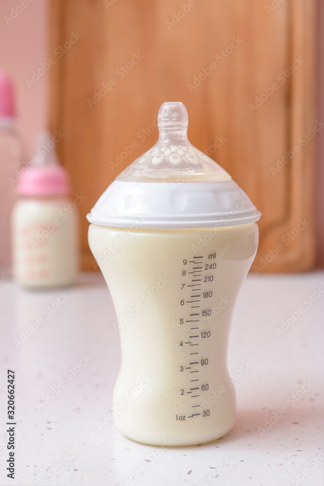 Bottle of milk for baby on white table