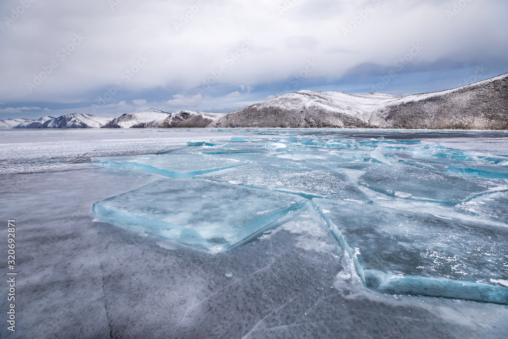 Winter landscape with detailed ice pattern foreground on a frozen lake. Lake Baikal, Irkutsk, Siberi