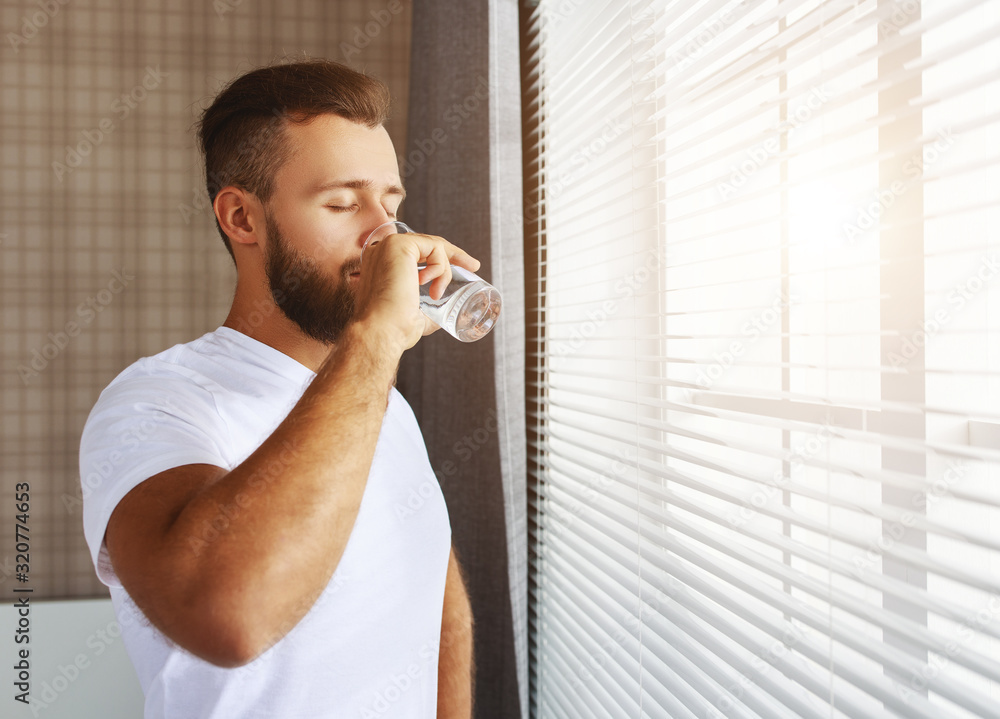 young healthy man drinking water in morning