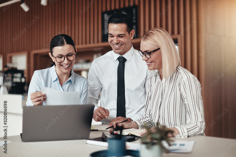 Smiling young businesspeople working at a table in an office