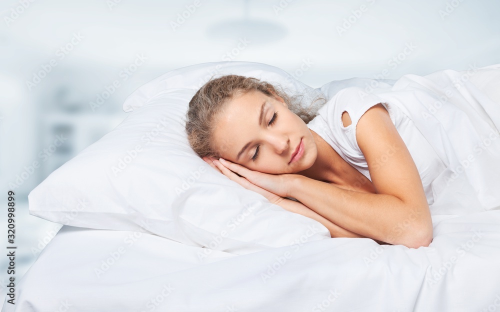 Young woman sleeping on the white linen in bed