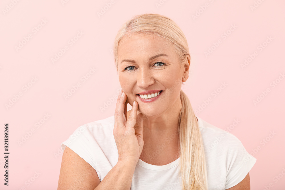 Beautiful mature woman with healthy skin on color background