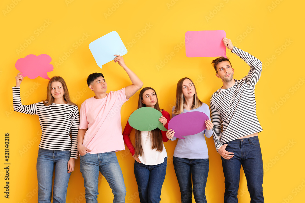 Group of young people with blank speech bubbles on color background