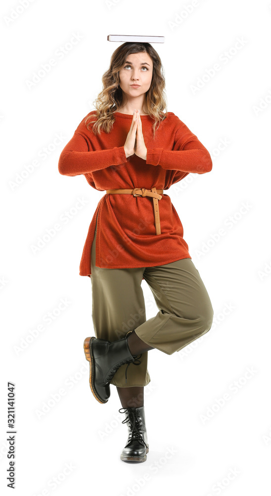 Beautiful meditating young woman with book on white background