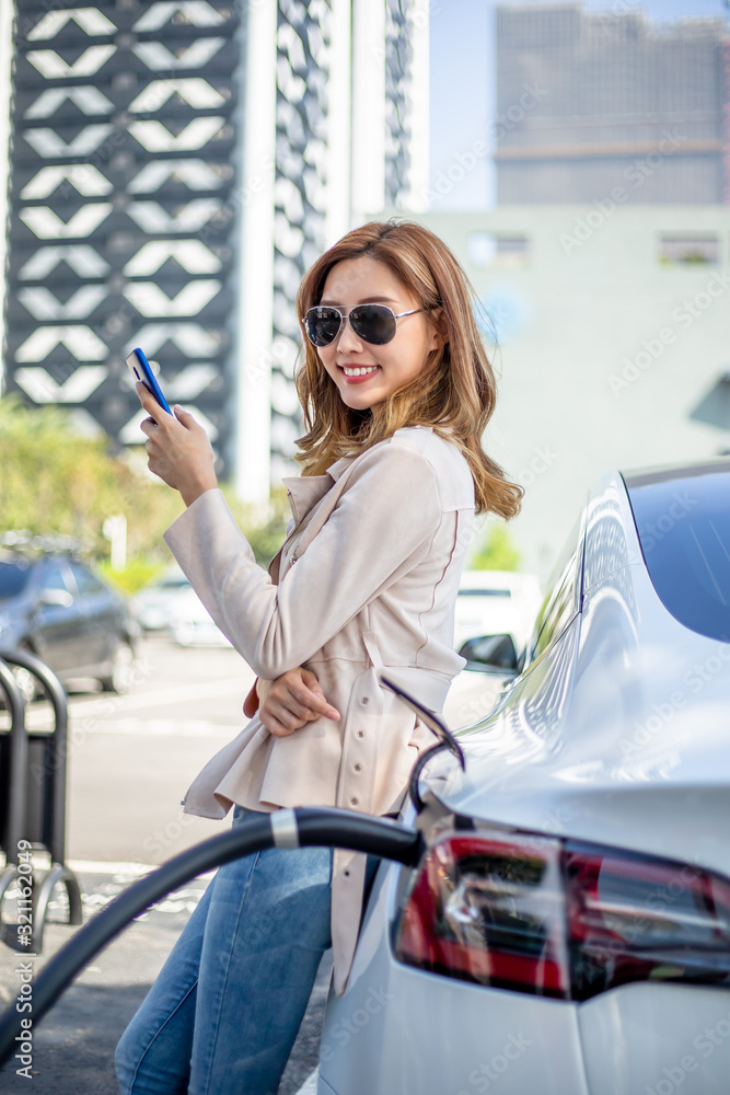 Woman charging electric car