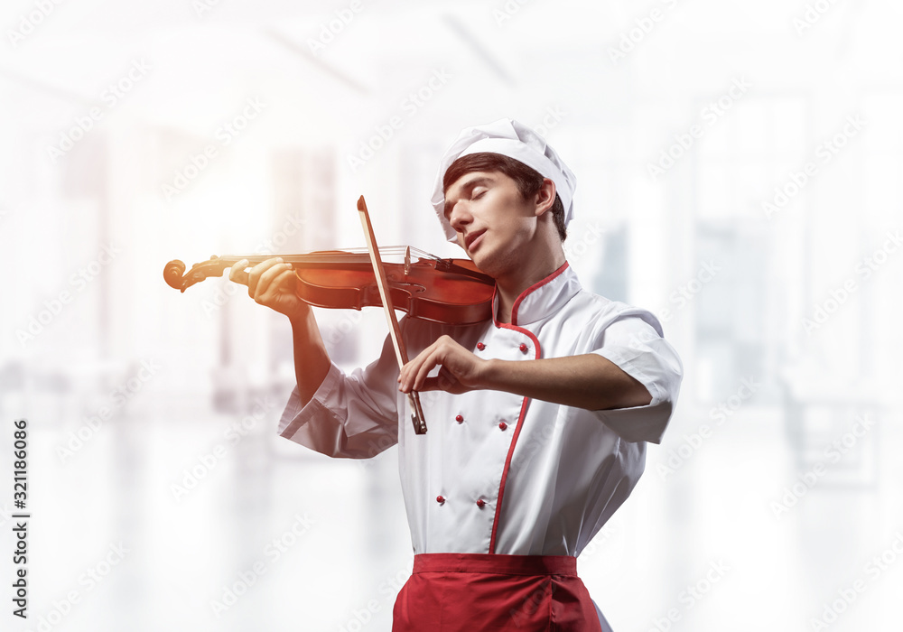 Young male chef with violin standing