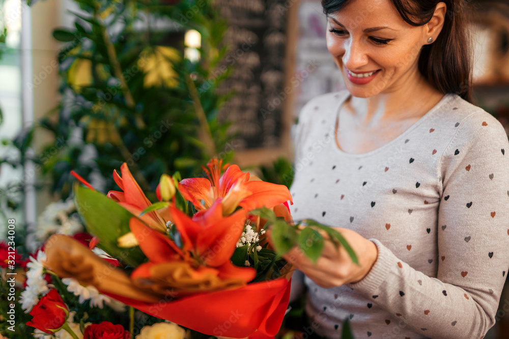 Happy woman holding lily decorated lily bouquet, portrait.