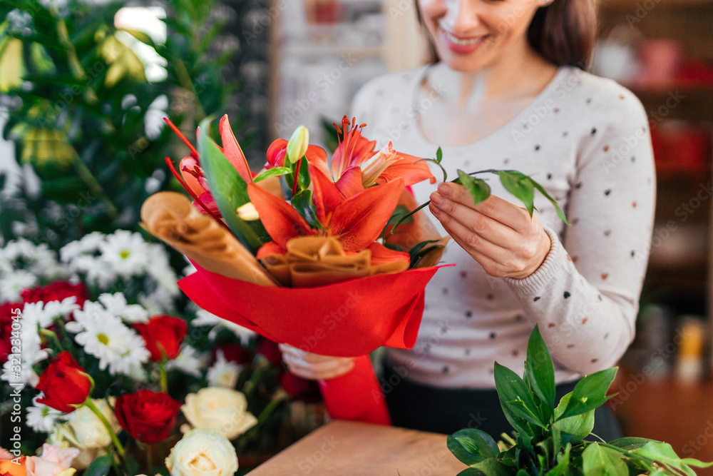 Close-up image of creative florist making red bouquet.