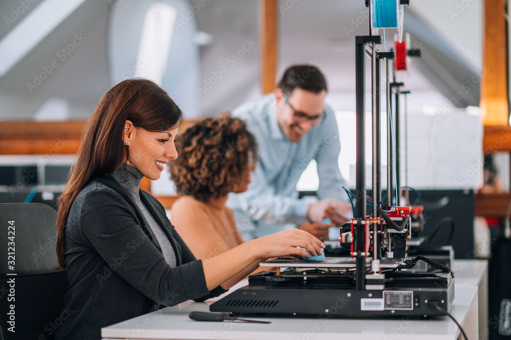 Beautiful woman working in the lab using a 3D printer.