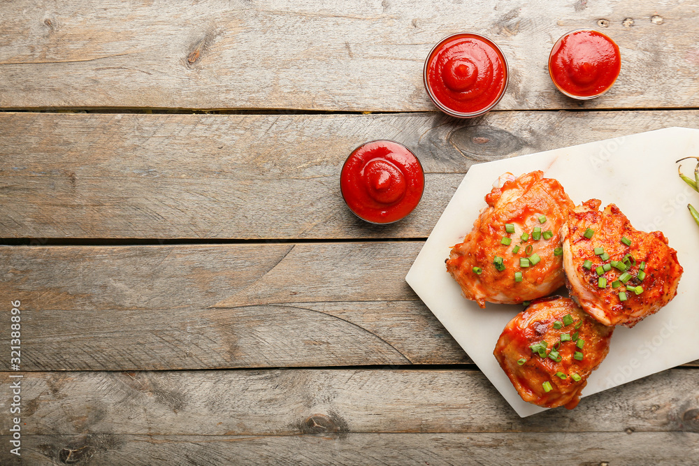 Cooked chicken thighs with tomato sauce on table