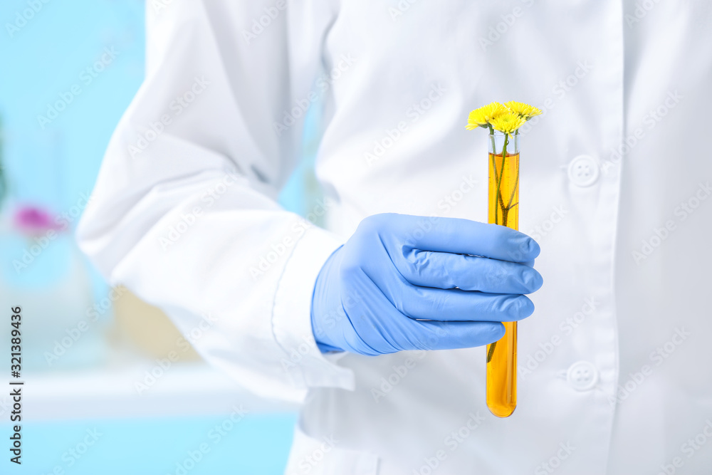 Scientist with sample of flowers in laboratory