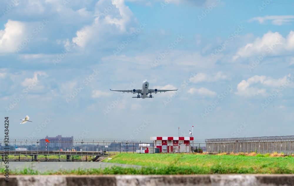 Passenger plane takes off at airport with beautiful blue sky and white fluffy clouds. Leaving flight