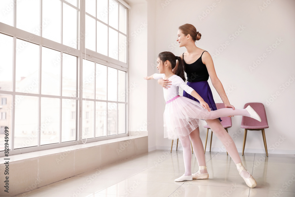 Little ballerina training with coach in dance studio