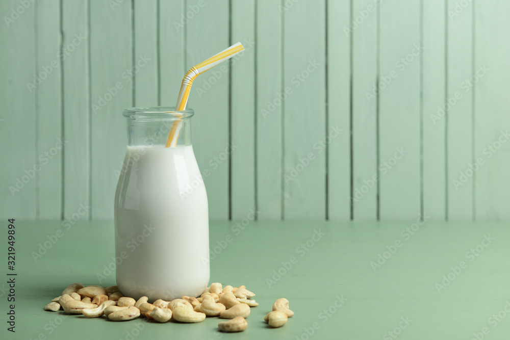 Bottle of cashew milk on color background