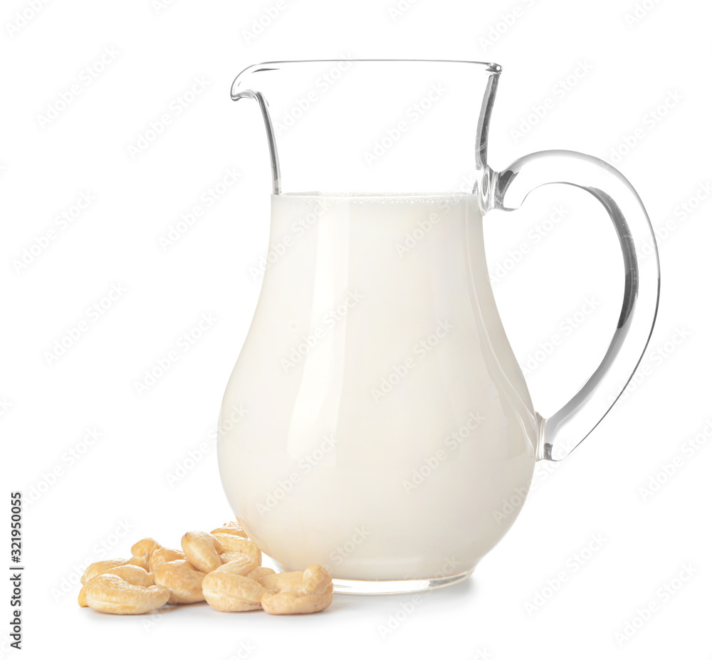 Jug of fresh cashew milk on white background