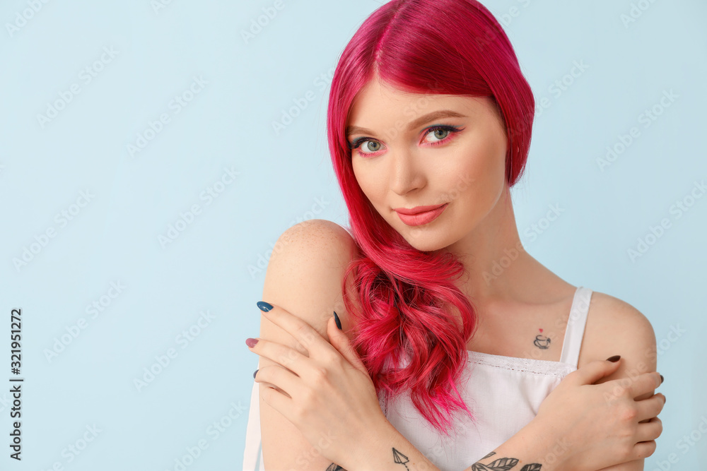 Beautiful young woman with unusual hair on color background