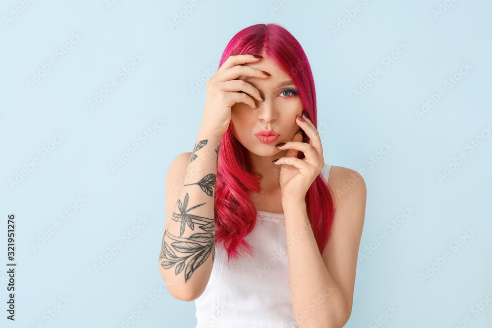 Beautiful young woman with unusual hair on color background