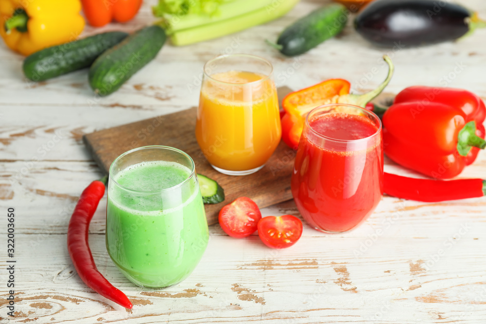 Glasses of fresh vegetable juices on white table