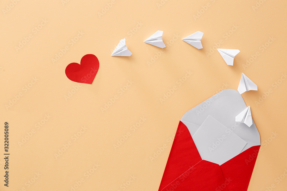 Composition with envelope, paper airplanes and heart on color background