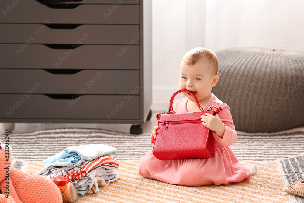 Cute baby girl with stylish clothes and accessories at home