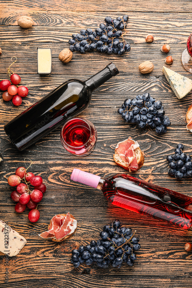 Delicious wine with snacks on wooden background