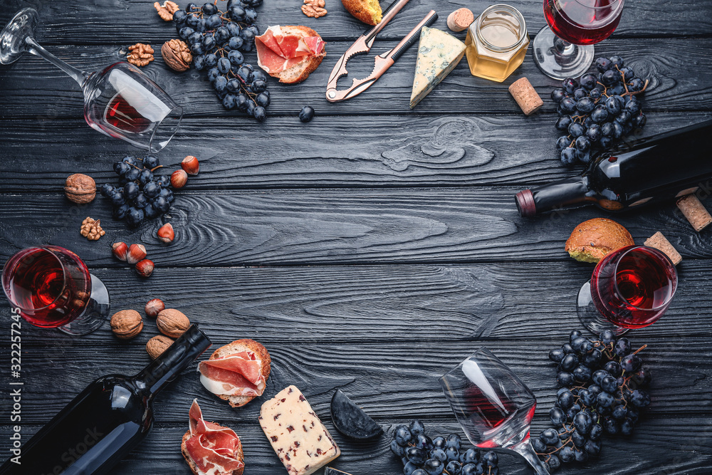 Frame made of delicious wine with snacks on dark wooden background