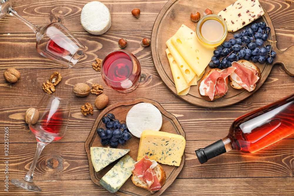 Delicious wine with snacks on wooden background