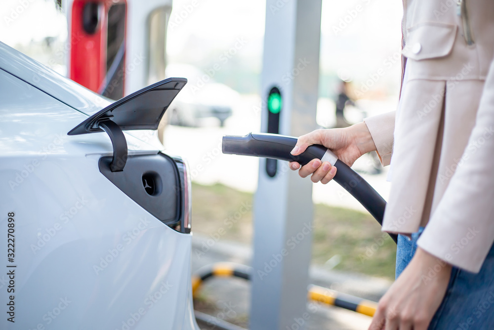 Woman charging electric car